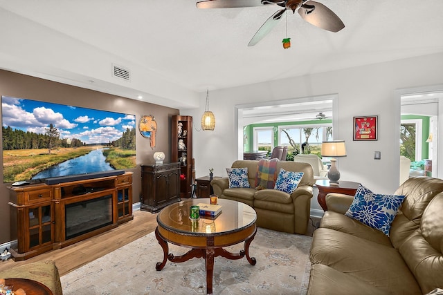 living room featuring light hardwood / wood-style floors and ceiling fan