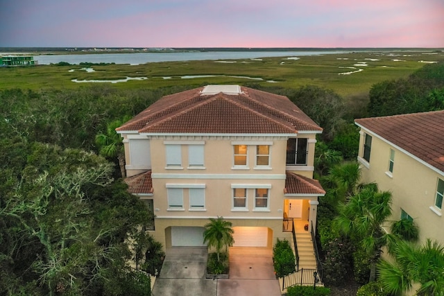 view of front of house with a garage and a water view