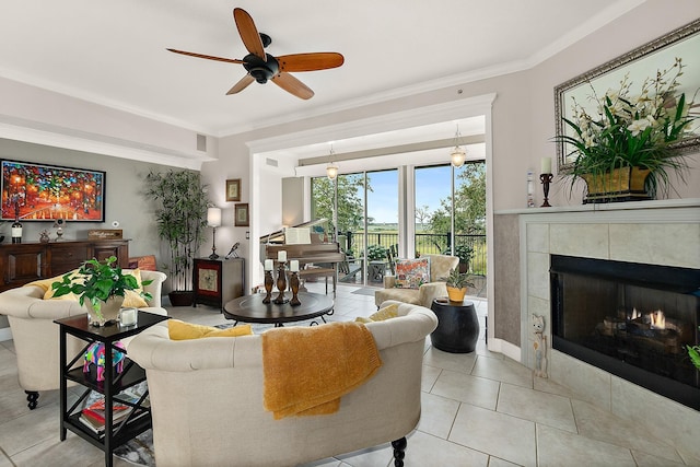 tiled living room with a tile fireplace, ceiling fan, and ornamental molding