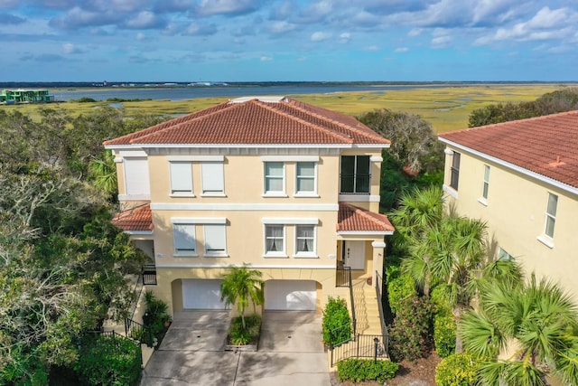 1602 Windjammer Ln, Saint Augustine, FL 32084 - mediterranean / spanish house with a tile roof, concrete driveway, stucco siding, a garage, and a water view