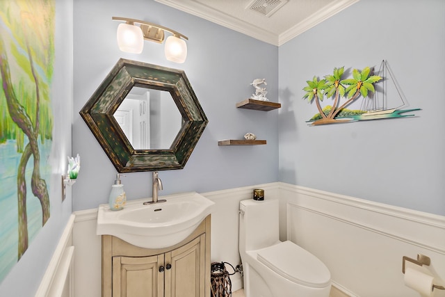 bathroom featuring crown molding, vanity, and toilet