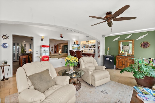 living room featuring bar area, ceiling fan, and light tile patterned flooring