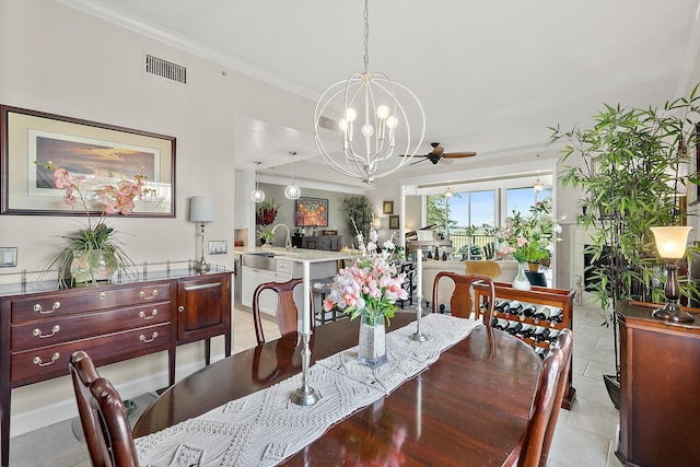 dining space featuring light tile patterned flooring, ceiling fan with notable chandelier, crown molding, and sink