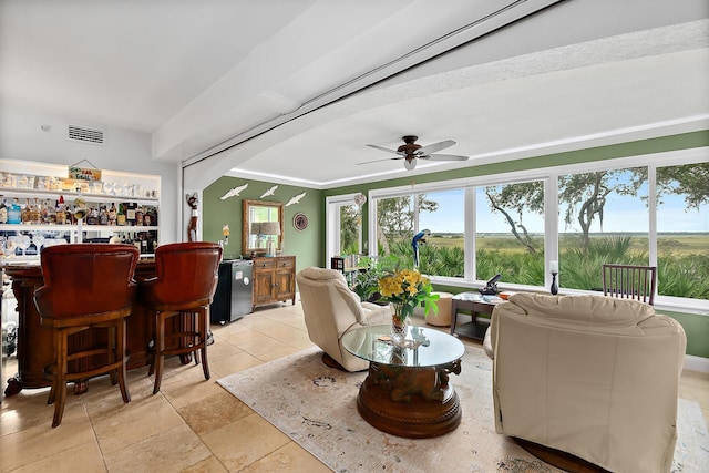 living room featuring ceiling fan and bar area