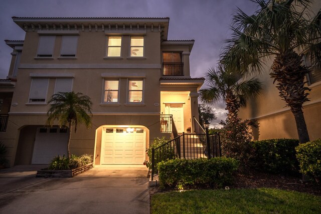 1602 Windjammer Ln, Saint Augustine, FL 32084 - mediterranean / spanish house featuring concrete driveway, an attached garage, stucco siding, a balcony, and stairway