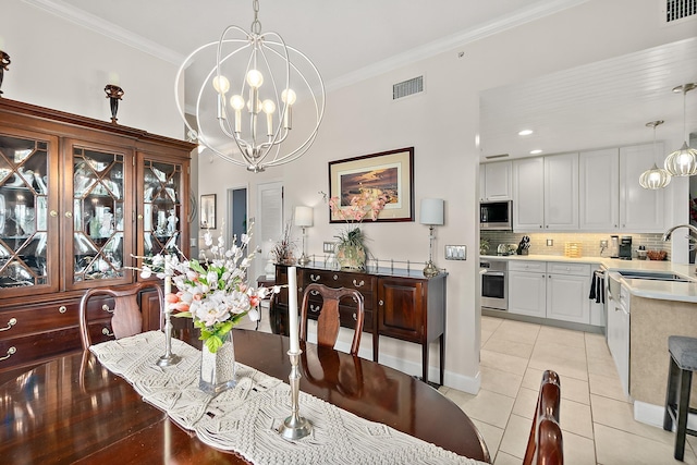 dining area featuring light tile patterned floors, crown molding, a notable chandelier, and sink