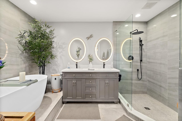 bathroom with vanity and shower with separate bathtub