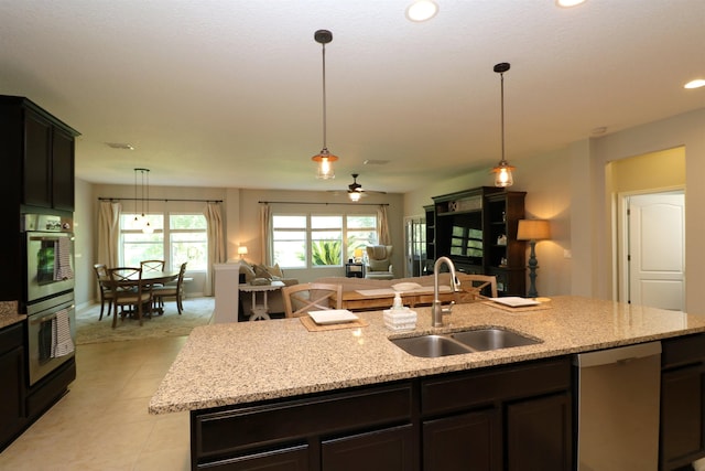 326 Gianna Way, Saint Augustine, FL 32086 - kitchen with stainless steel appliances, open floor plan, hanging light fixtures, a center island with sink, and light stone countertops