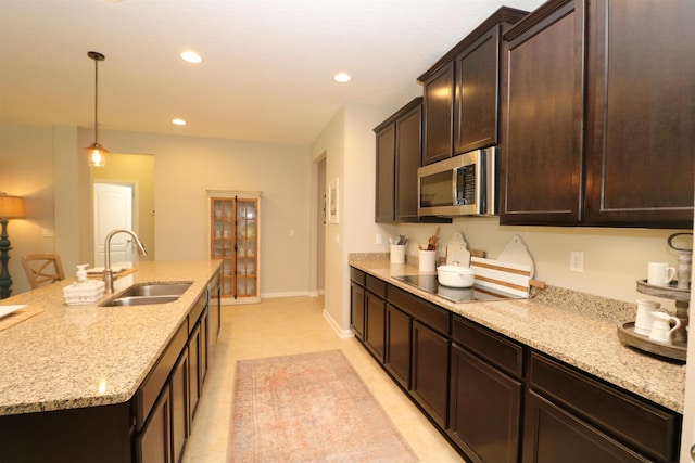 326 Gianna Way, Saint Augustine, FL 32086 - kitchen with stainless steel microwave, black electric cooktop, dark brown cabinetry, recessed lighting, and light stone countertops