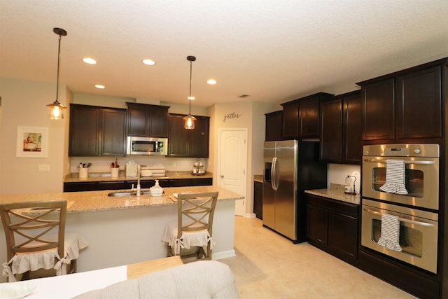 326 Gianna Way, Saint Augustine, FL 32086 - kitchen featuring appliances with stainless steel finishes, light stone countertops, pendant lighting, a kitchen bar, and recessed lighting