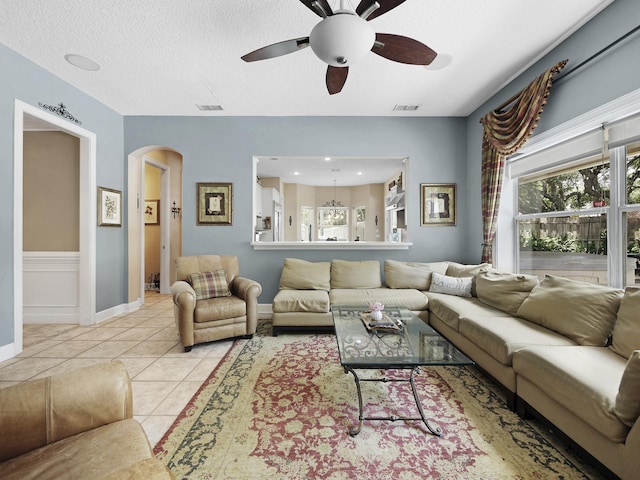 304 1st St, Saint Augustine, FL 32084 - living area with arched walkways, ceiling fan, tile patterned flooring, and a textured ceiling