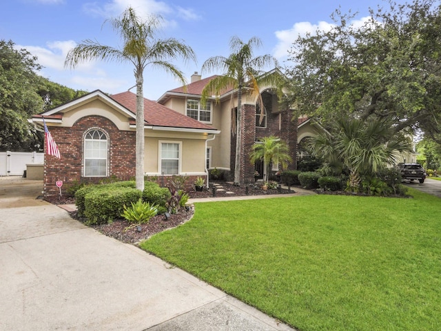 304 1st St, Saint Augustine, FL 32084 - view of front facade with stucco siding, driveway, brick siding, and a shingled roof