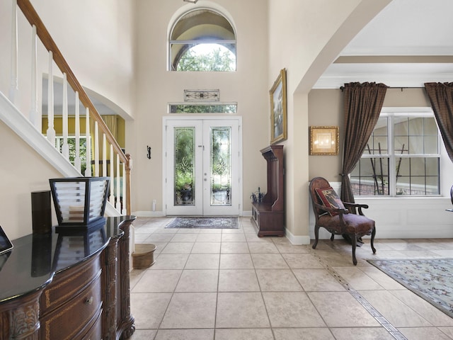 304 1st St, Saint Augustine, FL 32084 - entryway with arched walkways, stairway, light tile patterned floors, and a towering ceiling