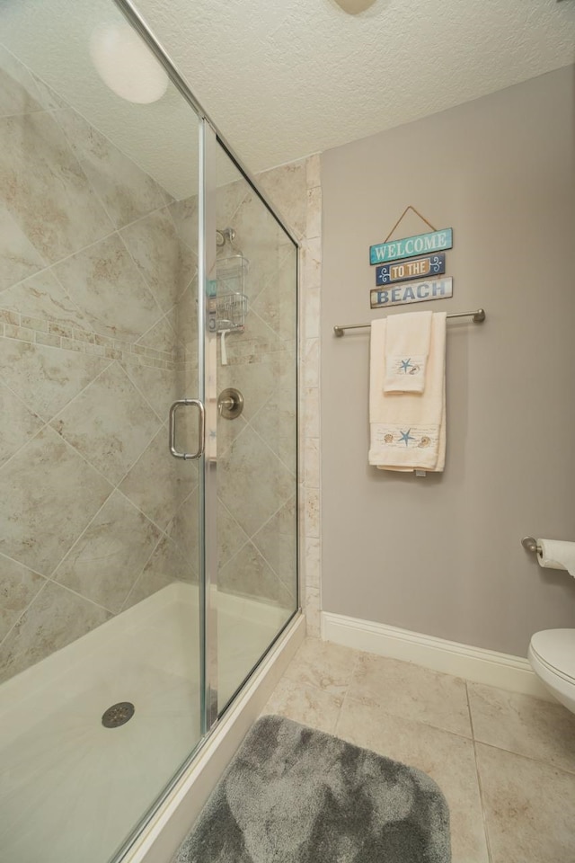 bathroom with walk in shower, toilet, tile patterned flooring, and a textured ceiling