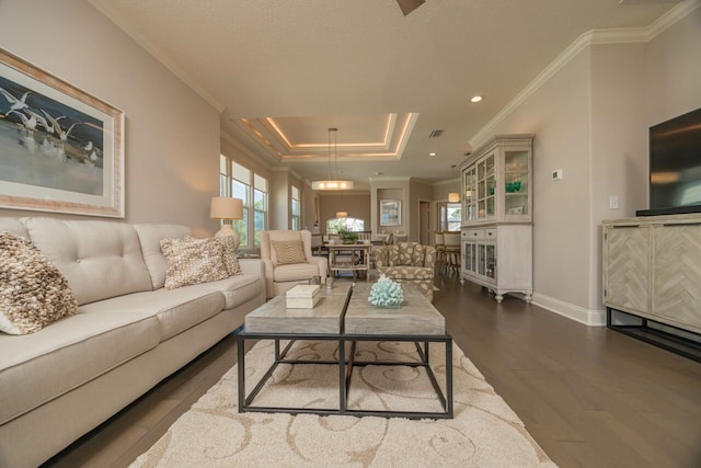 living room featuring a tray ceiling, ornamental molding, and hardwood / wood-style flooring