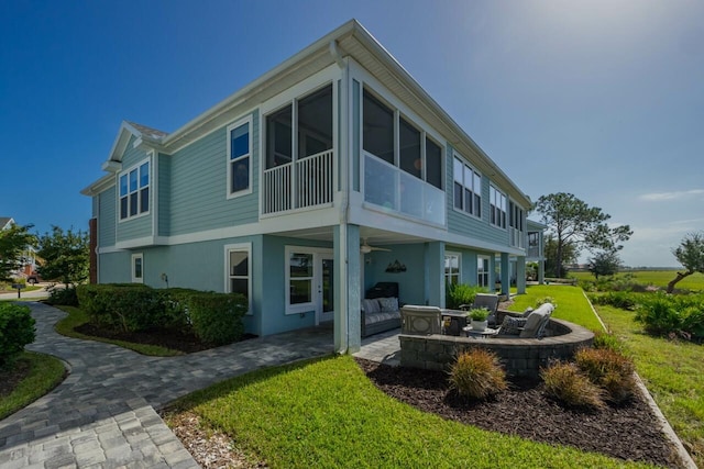 back of property with an outdoor living space, a yard, and a patio area