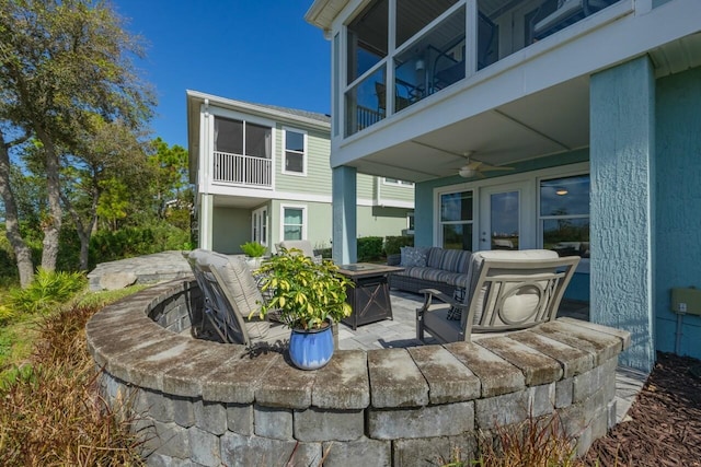 view of patio / terrace with a balcony, an outdoor living space with a fire pit, and ceiling fan