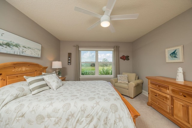 bedroom featuring light carpet, a textured ceiling, and ceiling fan