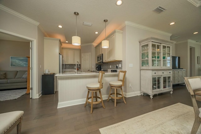 kitchen featuring appliances with stainless steel finishes, decorative backsplash, hanging light fixtures, kitchen peninsula, and dark wood-type flooring