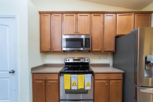 142 Patriot Ln, Elkton, FL 32033 - kitchen with appliances with stainless steel finishes, vaulted ceiling, and brown cabinets