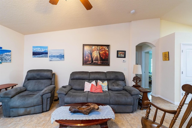 142 Patriot Ln, Elkton, FL 32033 - living area featuring lofted ceiling, arched walkways, light tile patterned flooring, ceiling fan, and a textured ceiling