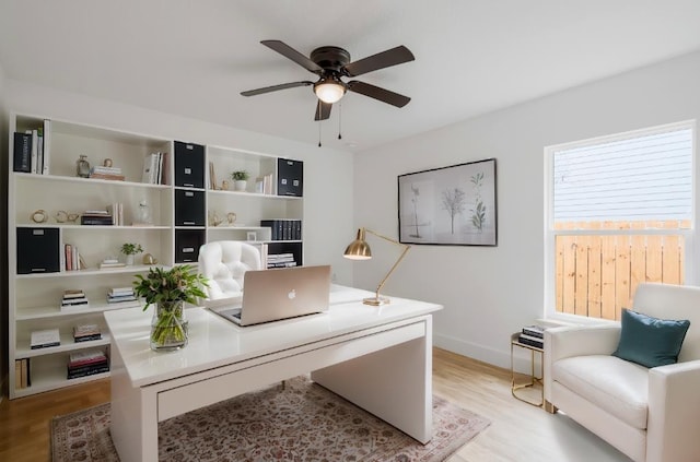 office with light hardwood / wood-style flooring and ceiling fan