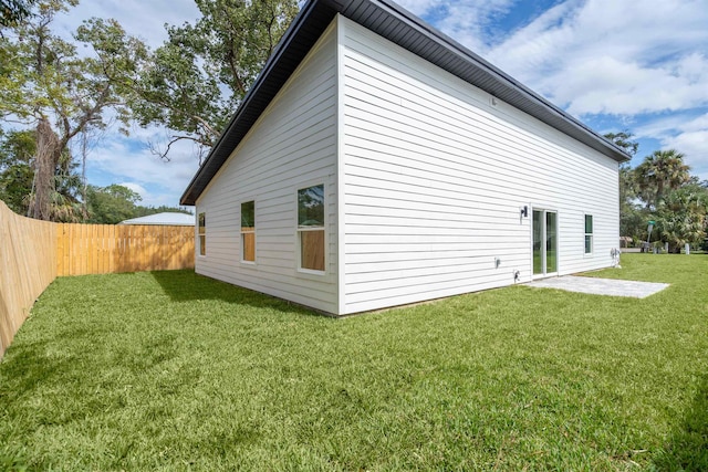 view of property exterior with a patio area and a lawn