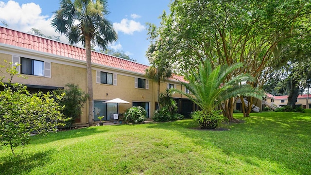 5811 Atlantic Blvd Unit 57, Jacksonville, FL 32207 - back of property featuring a tiled roof, stucco siding, and a lawn