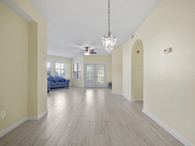 2200 Vista Cove Rd, Saint Augustine, FL 32084 - unfurnished living room with light wood-style flooring, ceiling fan with notable chandelier, and baseboards