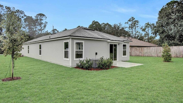 rear view of property featuring central AC unit, a patio area, and a yard