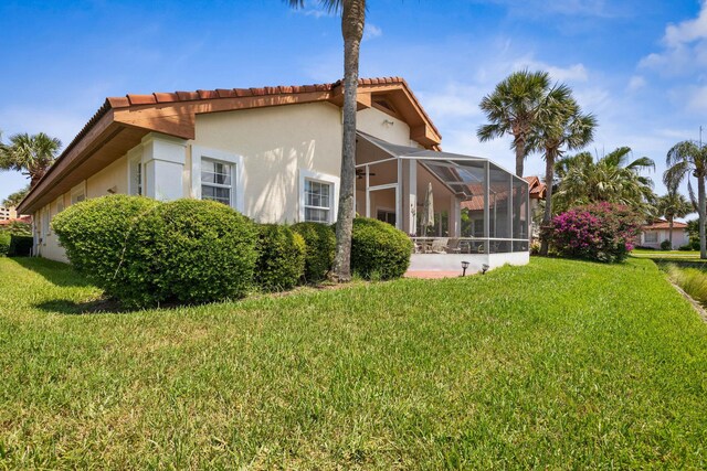 19 San Rafael Ct, Palm Coast, FL 32137 - rear view of house featuring stucco siding, a tiled roof, a yard, and glass enclosure