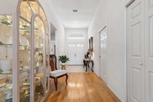 19 San Rafael Ct, Palm Coast, FL 32137 - foyer entrance with light wood finished floors, a textured ceiling, and baseboards