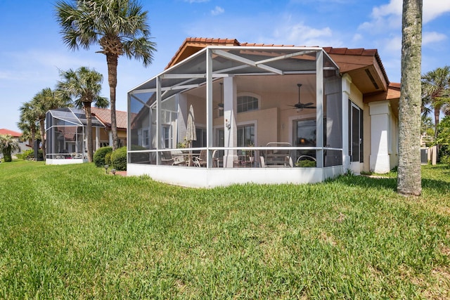 19 San Rafael Ct, Palm Coast, FL 32137 - back of house with a ceiling fan, stucco siding, a tile roof, and a yard