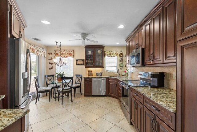 19 San Rafael Ct, Palm Coast, FL 32137 - kitchen featuring appliances with stainless steel finishes, decorative backsplash, a ceiling fan, light tile patterned floors, and hanging light fixtures