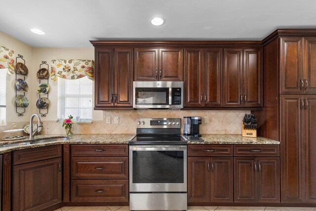 19 San Rafael Ct, Palm Coast, FL 32137 - kitchen with appliances with stainless steel finishes, a sink, backsplash, light stone counters, and recessed lighting