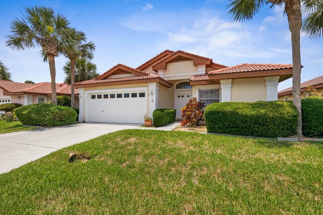 19 San Rafael Ct, Palm Coast, FL 32137 - mediterranean / spanish house featuring stucco siding, a garage, a front lawn, and driveway