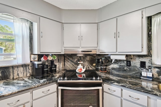 kitchen with decorative backsplash, white cabinetry, and stainless steel range with electric cooktop