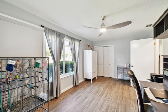 office space featuring ceiling fan, a textured ceiling, and light hardwood / wood-style flooring