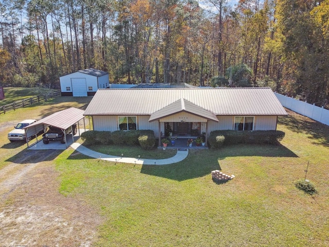 single story home featuring a carport, an outdoor structure, and a front yard