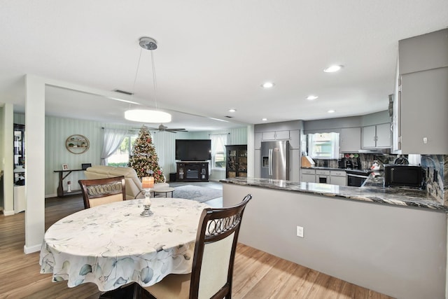 dining space with light wood-type flooring, plenty of natural light, and ceiling fan