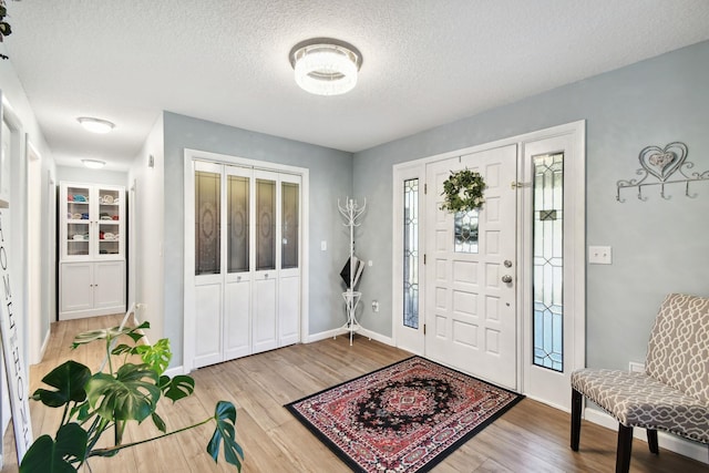 foyer featuring wood-type flooring and a textured ceiling