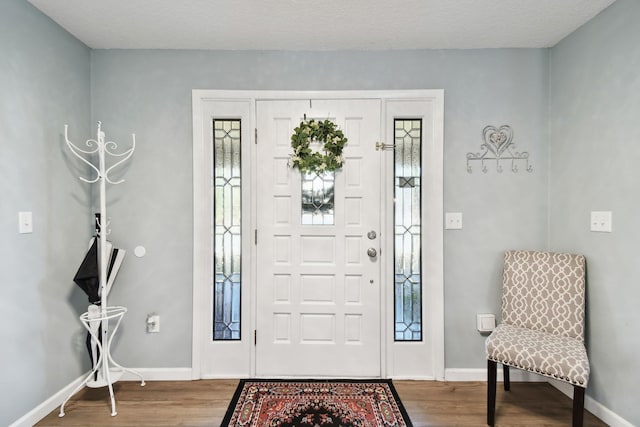 foyer entrance featuring wood-type flooring and a textured ceiling