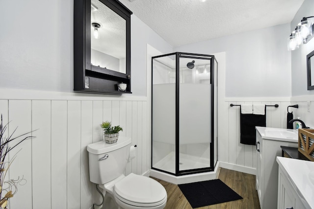 bathroom featuring hardwood / wood-style floors, vanity, an enclosed shower, and a textured ceiling