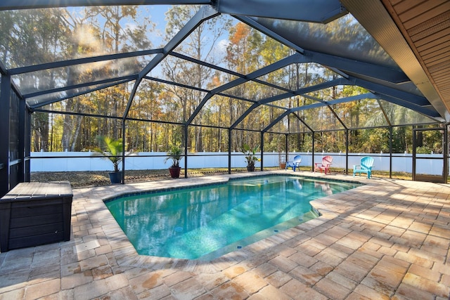 view of pool with glass enclosure and a patio