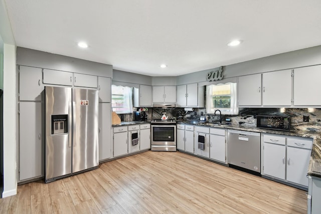 kitchen with a healthy amount of sunlight, light wood-type flooring, sink, and appliances with stainless steel finishes