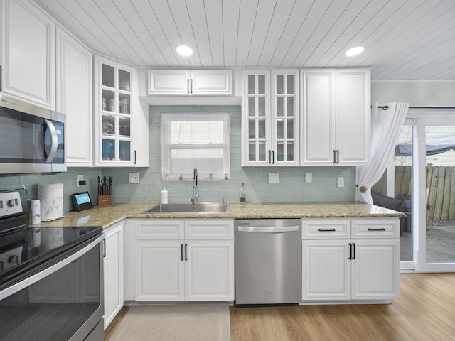 kitchen featuring appliances with stainless steel finishes, white cabinetry, and sink