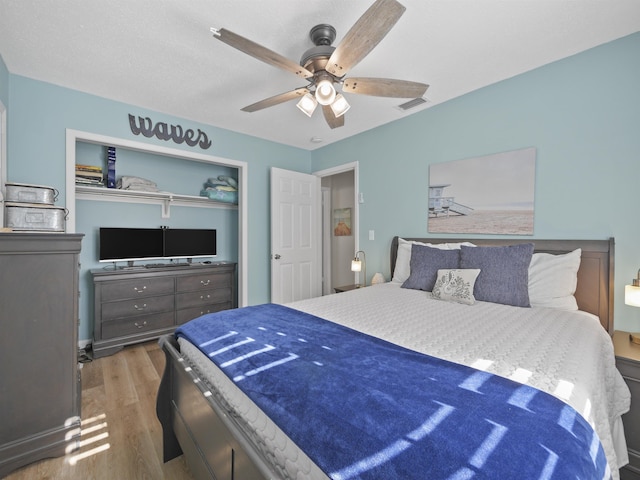 bedroom featuring ceiling fan, a closet, and wood-type flooring