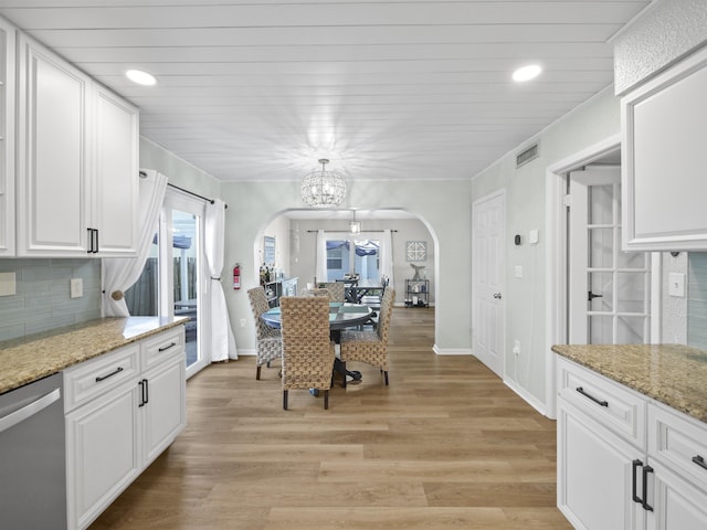 kitchen featuring dishwasher, a chandelier, light hardwood / wood-style floors, light stone countertops, and white cabinetry