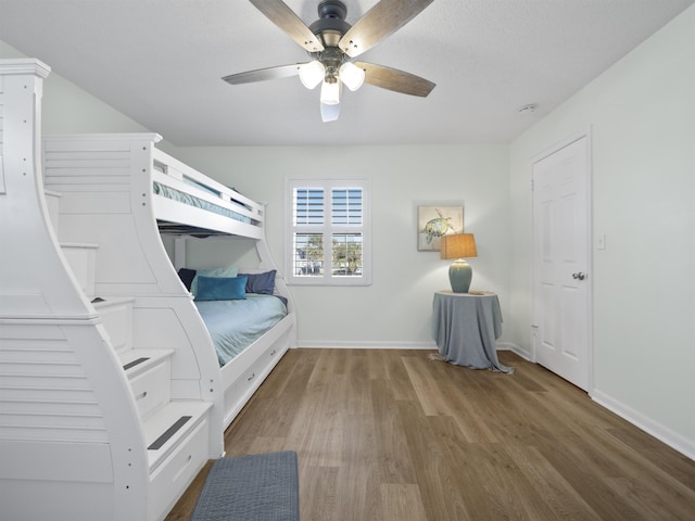 unfurnished bedroom with a ceiling fan, baseboards, and wood finished floors