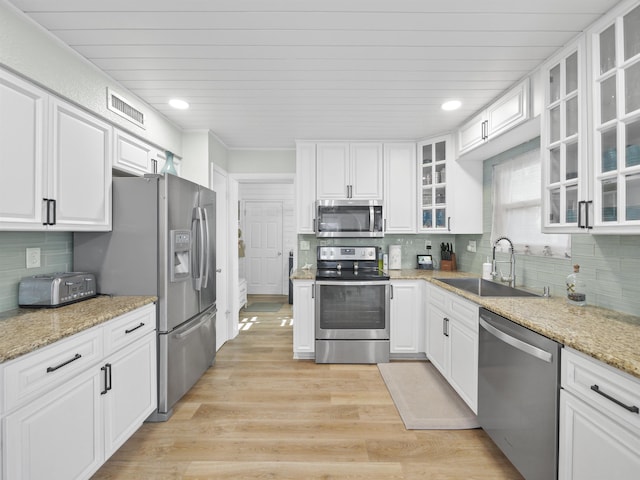 kitchen with light wood finished floors, visible vents, white cabinets, stainless steel appliances, and a sink